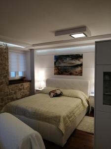 una camera da letto con un letto e un dipinto sul muro di V&M Luxury Studio a Pag
