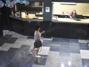 una mujer caminando delante de un mostrador con una cámara en Sunio City en Tijuana