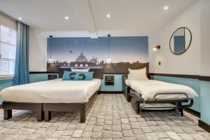 A bed or beds in a room at Hôtel Lucien & Marinette