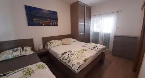 1 dormitorio con 2 camas y ventana en Apartments Villa Ravlić en Makarska