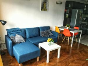 ein Wohnzimmer mit einem blauen Sofa und einem Tisch in der Unterkunft Apartament ul.Złota z widokiem na Pałac Kultury!!! in Warschau