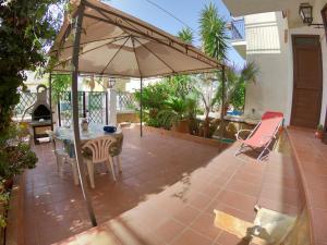 a patio with an umbrella and a table and chairs at SUN VITO - Casa Vacanze vicino la Spiaggia in San Vito lo Capo