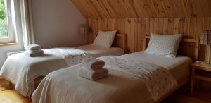 une chambre avec deux lits avec des serviettes dessus dans l'établissement Dom Nad Potokiem, à Proszowa