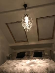 a chandelier hanging over a bed in a room at B&B Bij Bijnen in Soerendonk