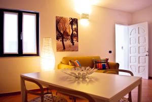 a living room with a table and a yellow couch at Bed And Breakfast Charming House in Barletta