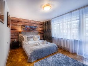 um quarto com uma cama e uma grande janela em Apartament Krupówki Center em Zakopane