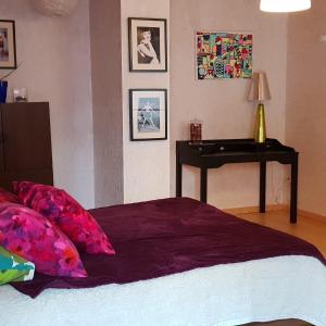 a bedroom with a bed with a table and pictures on the wall at LA POUDRIERE DE SAINT VENANT in Saint-Venant