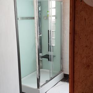 a shower in a bathroom with a glass door at LA POUDRIERE DE SAINT VENANT in Saint-Venant