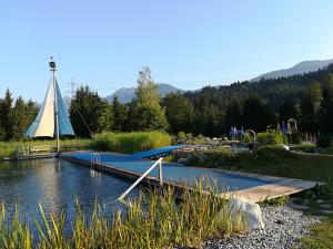 a playground with a bridge over the water with a tent at Ferienwohnung Millonigg in Vorderberg