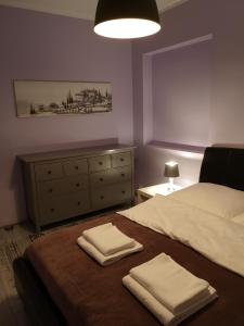 a bedroom with a bed with two folded towels on it at Apartamenty Lawendowy Zakątek 1 in Opole
