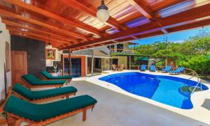 a patio with a pool and lounge chairs and a swimming pool at Galapagos Cottages in Puerto Ayora