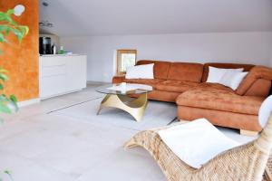 ein Wohnzimmer mit einem braunen Sofa und einem Tisch in der Unterkunft Ferienwohnung Sonne in Kurort Gohrisch