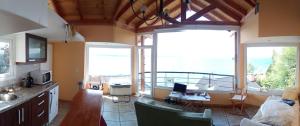 eine Küche mit einem Wohnzimmer und einem großen Fenster in der Unterkunft Cabañas Barlovento in San Carlos de Bariloche