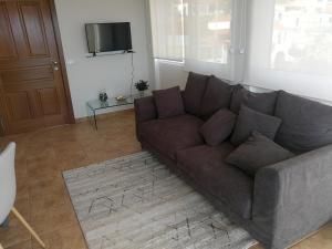 ein Wohnzimmer mit einem Sofa und einem TV in der Unterkunft Casa do Imaculado in Funchal