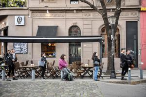een groep mensen die aan tafels buiten een gebouw zitten bij Soho Luxury Loft in Buenos Aires