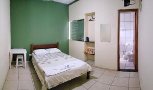 a bedroom with a bed and a bathroom at HOTEL CENTRAL in Juruaia