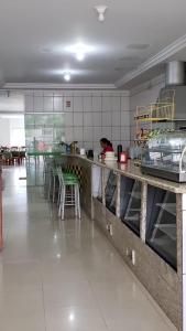 a kitchen with a counter and a person in the kitchen at HOTEL CENTRAL in Juruaia