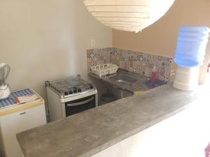 a kitchen with a stove and a sink and a counter at Stay Cool Pipa in Pipa