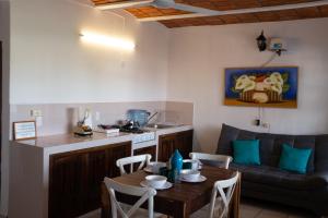 a living room with a table and a kitchen at Madre Cuixe Suites in La Peñita de Jaltemba