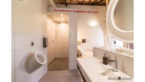 baño con urinario, lavabo y espejo en Faro Town House en Faro