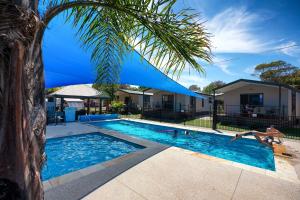 a swimming pool with a pool table and chairs at Barwon River Holiday Park in Geelong