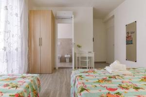 ein Schlafzimmer mit 2 Betten und ein Badezimmer in der Unterkunft Leolù Guesthouse Alghero in Alghero
