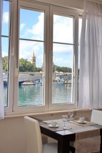 una mesa con 2 ventanas con vistas al agua en Accommodation Iva, en Zadar