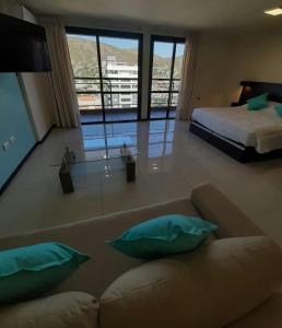 een woonkamer met een bank en een bed bij Miralejos 7 Turquesa in Villa Carlos Paz