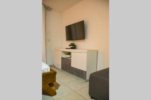 salon z kanapą i telewizorem na ścianie w obiekcie CHARMANT STUDIO DE STANDING GOSIER w mieście Le Gosier
