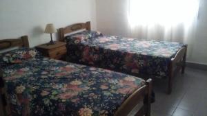 two beds in a room with flowers on them at Soleaditos in Mina Clavero