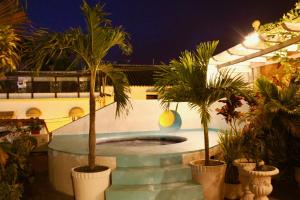 a beach with a pool and palm trees at Hotel Casa Gloria Boutique in Cartagena de Indias