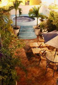a patio area with tables, chairs and umbrellas at Hotel Casa Gloria Boutique in Cartagena de Indias