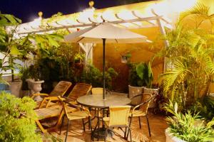 een patio met een tafel en stoelen en een parasol bij Hotel Casa Gloria Boutique in Cartagena
