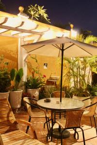 a patio area with a table, chairs, and a patio umbrella at Hotel Casa Gloria Boutique in Cartagena de Indias