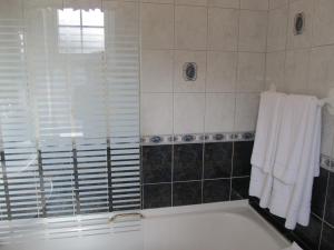 a bathroom with a tub and a window and towels at Neidin House in Kenmare
