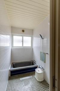 a bathroom with a bath tub and a toilet at North Point in Niseko