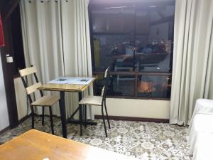 une chambre avec une table, des chaises et une fenêtre dans l'établissement Loft Santos Dumont, à Nova Friburgo