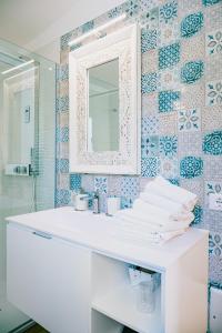 La salle de bains est pourvue d'un lavabo blanc et d'un miroir. dans l'établissement Una Perla Nel Verde, à Putignano