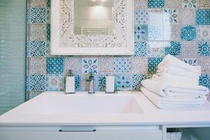La salle de bains est pourvue d'un lavabo blanc et d'un miroir. dans l'établissement Una Perla Nel Verde, à Putignano