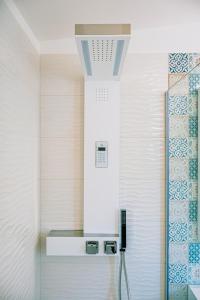 a shower in a bathroom with a tile wall at Una Perla Nel Verde in Putignano