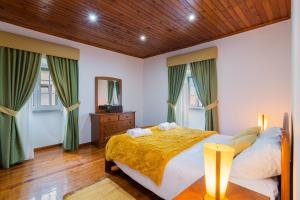 Un dormitorio con una cama grande y dos ventanas. en Casa Outeiro de Cima - Casa Rústica típica Serrana - Seia - SERRA DA ESTRELA, en Seia