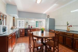 Una gran cocina con una mesa y sillas de madera. en Casa Outeiro de Cima - Casa Rústica típica Serrana - Seia - SERRA DA ESTRELA, en Seia
