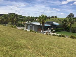 a house on a hill with a large yard at Pukeko Nest in Russell