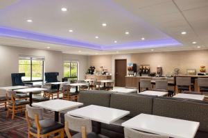 a restaurant with tables and chairs and a bar at La Quinta by Wyndham Lackawanna in Lackawanna