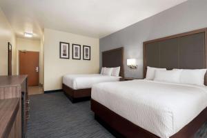 a hotel room with two beds and a television at AmericInn by Wyndham Appleton Airport in Appleton