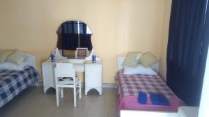 a room with two beds and a desk and a mirror at Buen Descanso in Salta