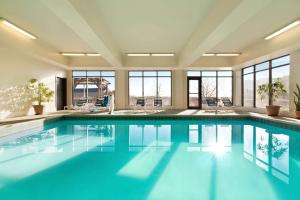 - une piscine d'eau bleue dans une chambre avec fenêtres dans l'établissement Wingate by Wyndham Denver Tech Center, à Greenwood Village