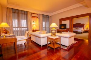 a living room with white furniture and a bedroom at Royale Chulan Kuala Lumpur in Kuala Lumpur