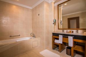 a bathroom with a tub and a sink at Royale Chulan Kuala Lumpur in Kuala Lumpur