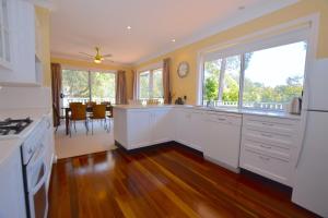 a kitchen with white cabinets and a large window at Rocky Mountain Cottage in Blackheath